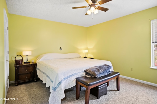 bedroom with carpet, ceiling fan, and a textured ceiling