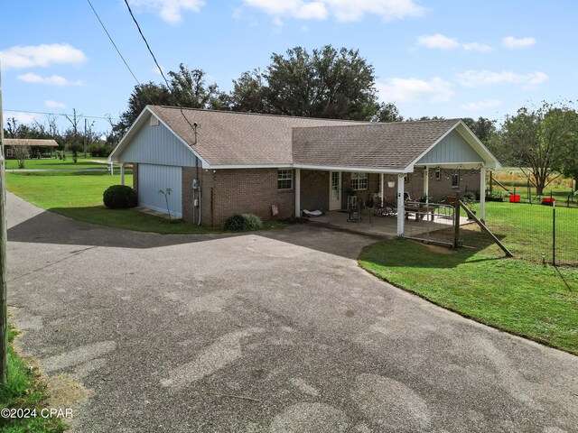 18496 NE Live Oak Ln, Blountstown, FL 32424 - view of front of property with a front lawn, covered porch, brick siding, and roof with shingles
