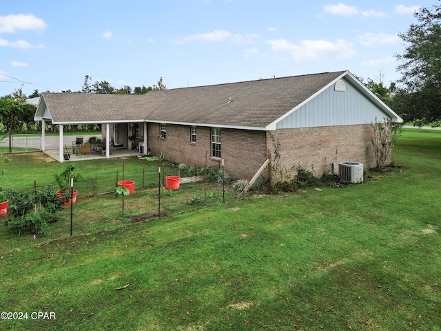 back of property featuring a lawn, a patio, and central AC