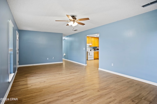 spare room with ceiling fan, a textured ceiling, and light hardwood / wood-style flooring