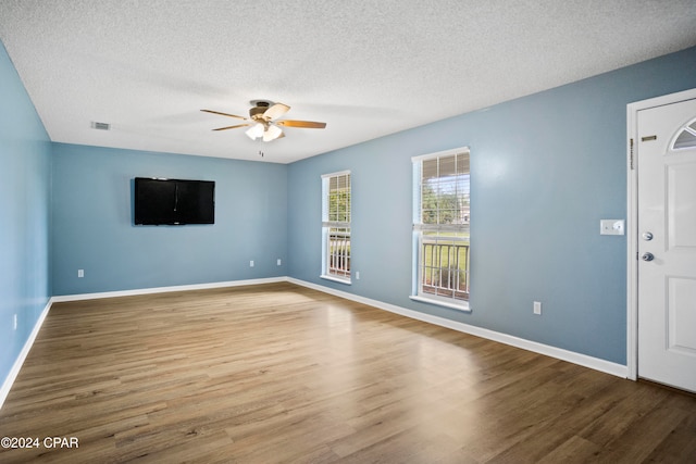 interior space with ceiling fan, wood-type flooring, and a textured ceiling