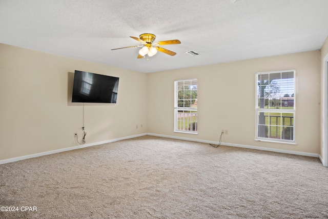 carpeted empty room with ceiling fan and a textured ceiling