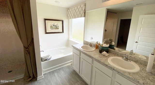 bathroom with wood-type flooring, vanity, and a tub