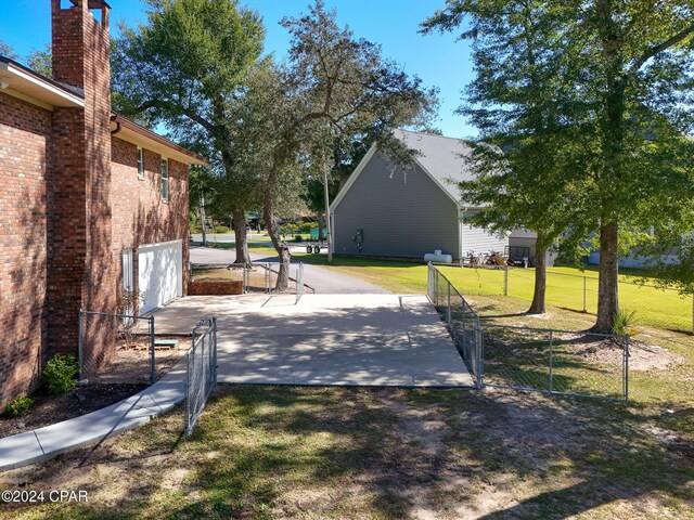 view of property exterior featuring a lawn, a balcony, and a garage