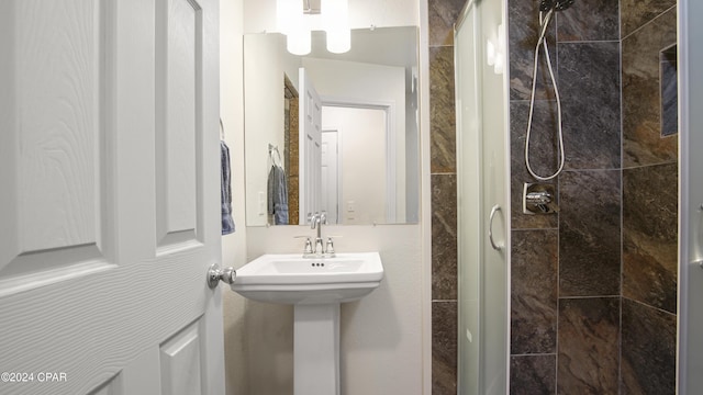 bathroom featuring a tile shower and sink