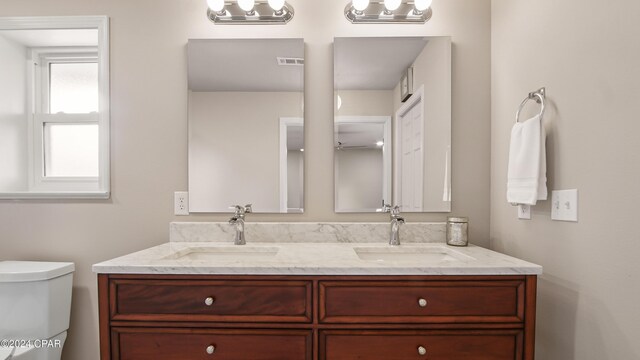 bedroom featuring ceiling fan, ensuite bathroom, and light hardwood / wood-style flooring