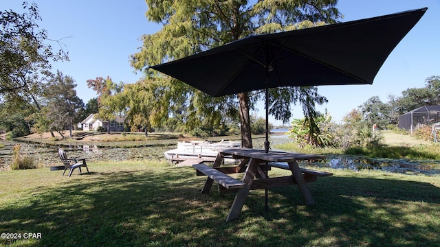 view of home's community with a water view and a yard