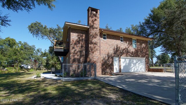 view of side of home featuring a balcony, a patio area, and a lawn