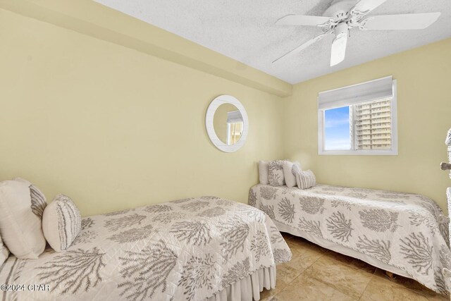 tiled dining space with a textured ceiling and ceiling fan