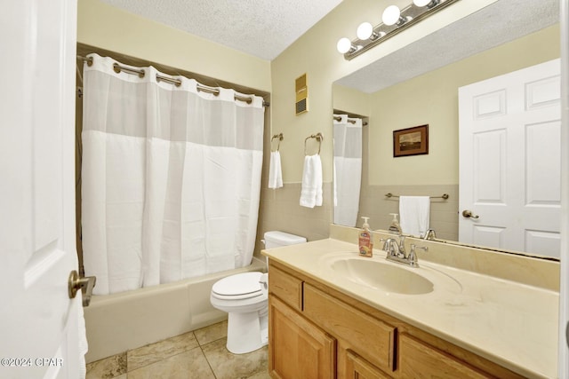 bathroom with a textured ceiling, tile patterned flooring, toilet, vanity, and tile walls