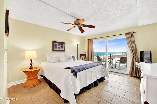 bedroom featuring ceiling fan, light tile patterned floors, a textured ceiling, and access to outside