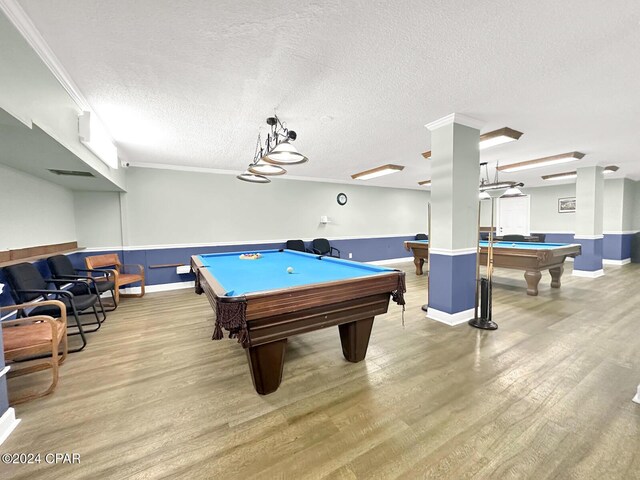 gym with hardwood / wood-style floors, a textured ceiling, and ornamental molding