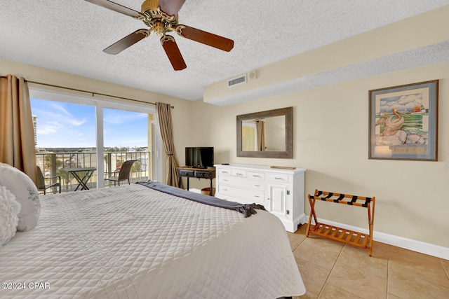 bedroom featuring access to outside, ceiling fan, light tile patterned floors, and a textured ceiling