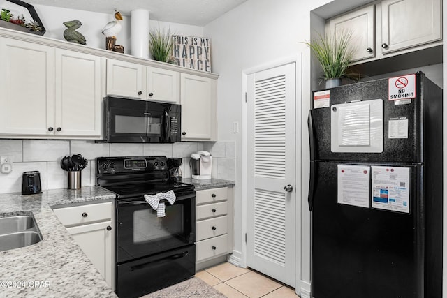 kitchen with backsplash, light stone counters, black appliances, white cabinets, and light tile patterned flooring