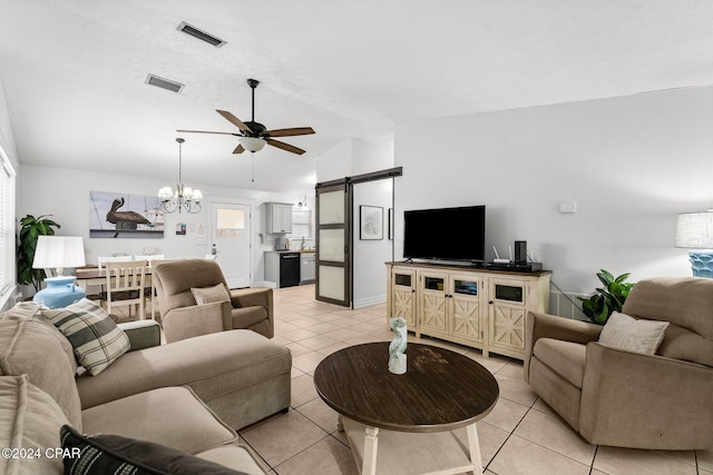 living room featuring ceiling fan with notable chandelier, a barn door, light tile patterned floors, and vaulted ceiling