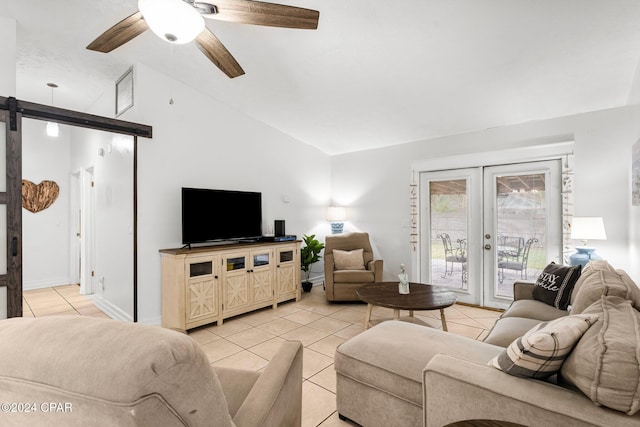 tiled living room featuring french doors, a barn door, vaulted ceiling, and ceiling fan