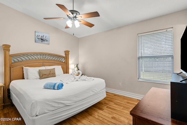 bedroom featuring hardwood / wood-style flooring, ceiling fan, and vaulted ceiling