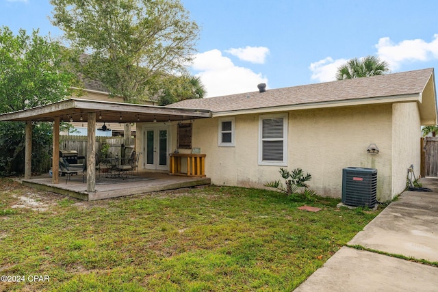 rear view of house featuring a lawn, french doors, central AC unit, and a deck