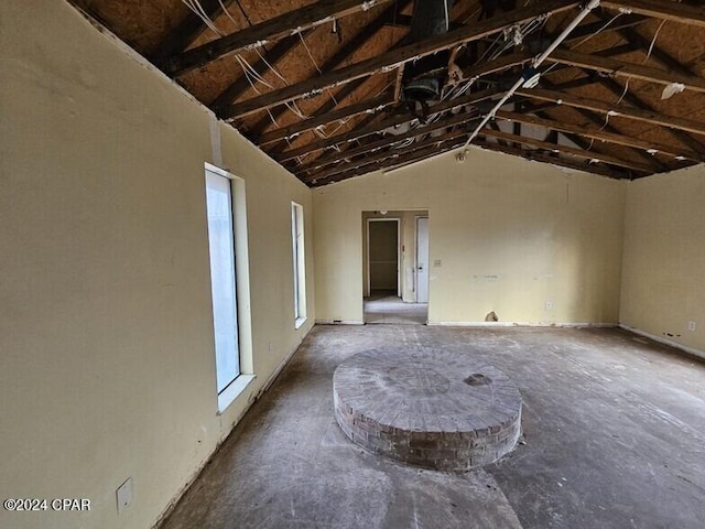 unfurnished living room with lofted ceiling with beams