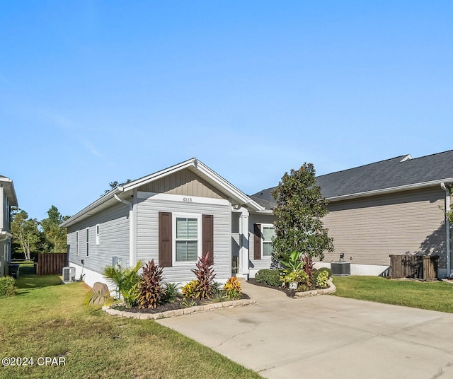 view of front of home with central AC and a front lawn