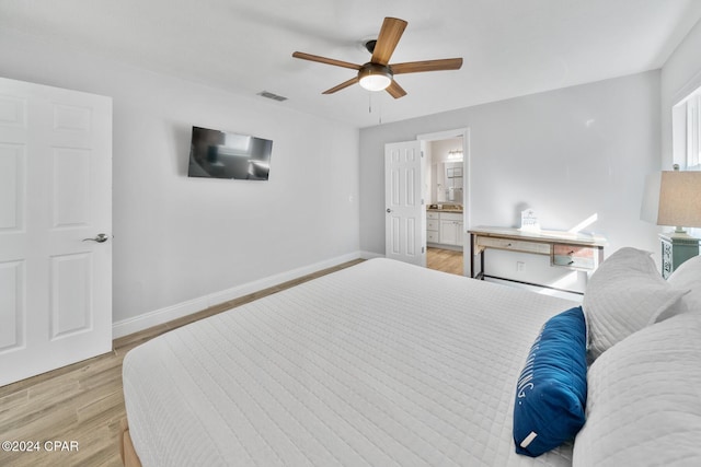 bedroom featuring ceiling fan, light wood-type flooring, and ensuite bathroom