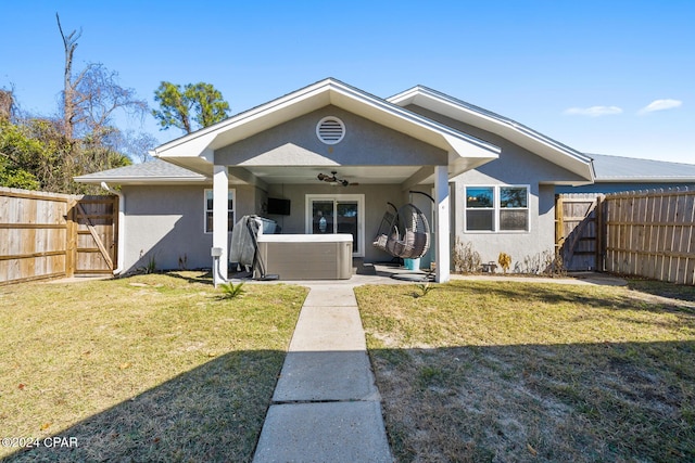 view of front of home with ceiling fan and a front yard