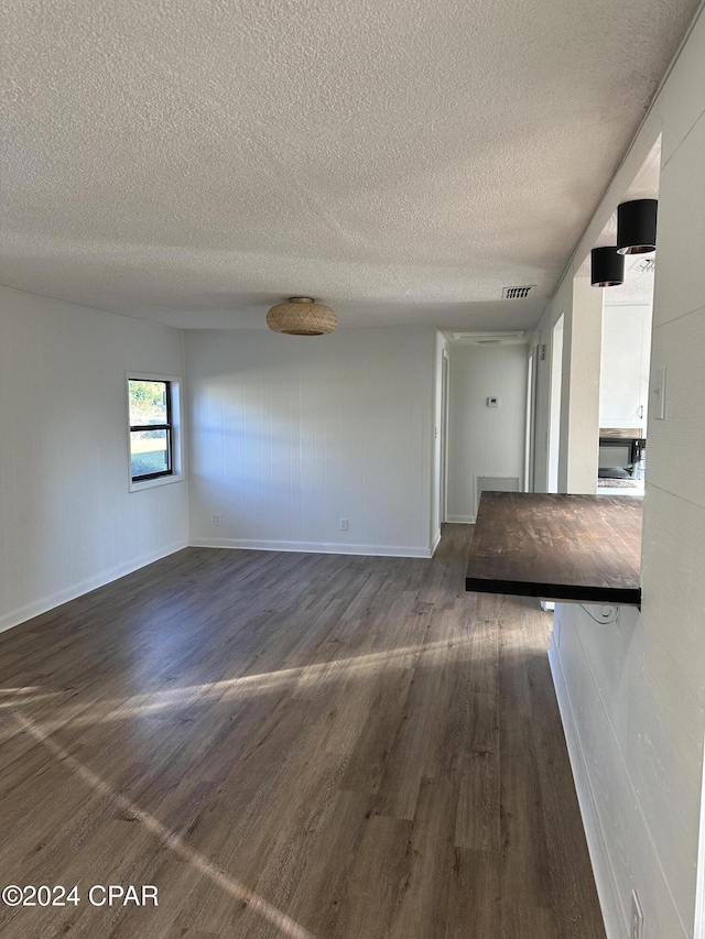 empty room featuring dark hardwood / wood-style floors and a textured ceiling