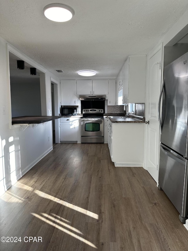 kitchen featuring dark hardwood / wood-style floors, white cabinetry, a textured ceiling, and appliances with stainless steel finishes