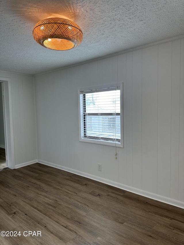 spare room with a textured ceiling and dark wood-type flooring