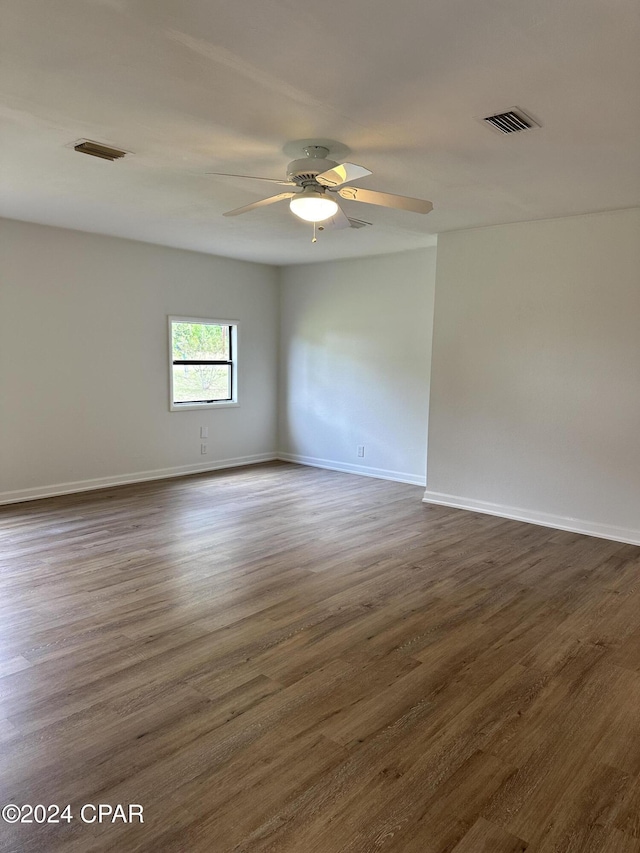 empty room featuring ceiling fan and dark hardwood / wood-style floors