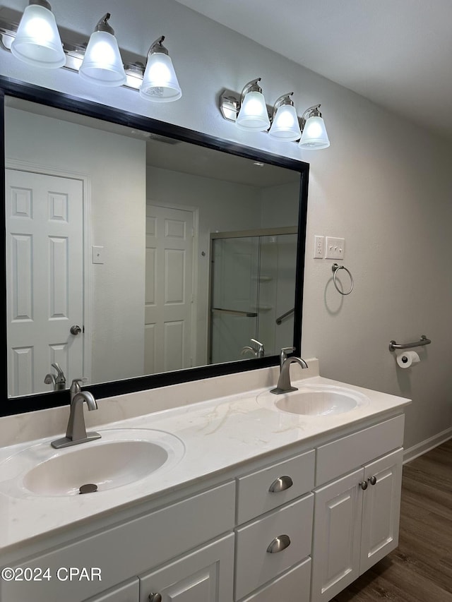 bathroom featuring wood-type flooring, vanity, and an enclosed shower