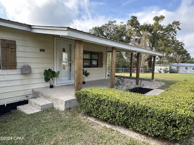 property entrance with a lawn