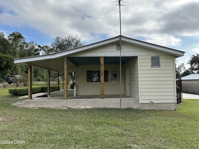 back of property featuring a patio area, a yard, and an AC wall unit