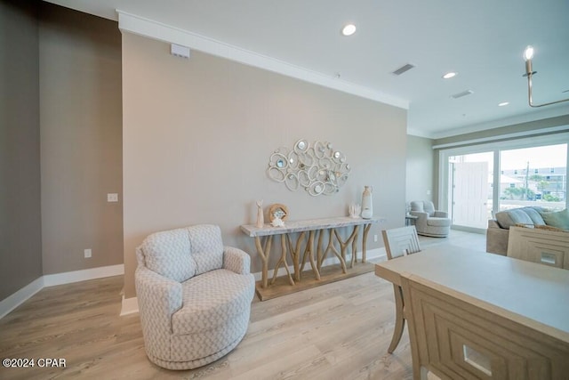 living area with light hardwood / wood-style flooring and ornamental molding