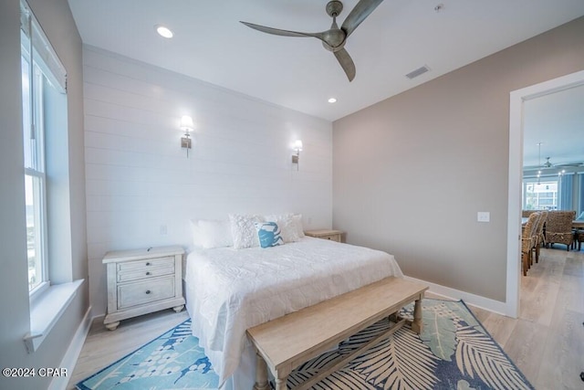 bedroom with multiple windows, ceiling fan, and light hardwood / wood-style flooring