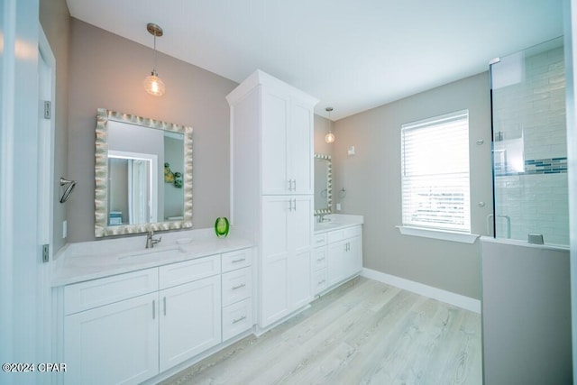 bathroom featuring hardwood / wood-style flooring, vanity, and an enclosed shower