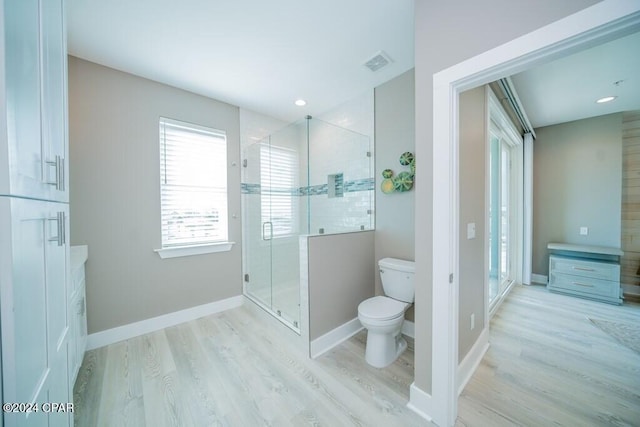 bathroom featuring toilet, an enclosed shower, and hardwood / wood-style flooring