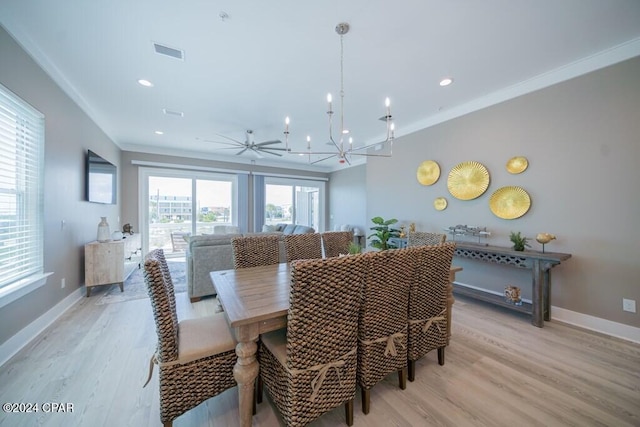 dining area featuring ceiling fan with notable chandelier, light wood-type flooring, and crown molding