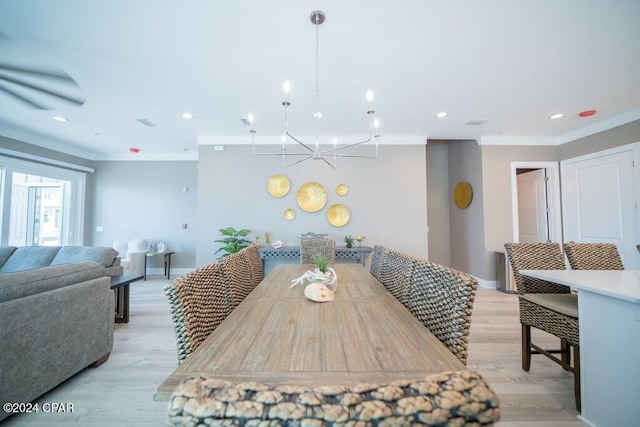 dining space with crown molding and light hardwood / wood-style floors