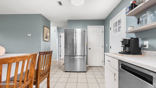 kitchen with white cabinetry, stainless steel appliances, and light tile patterned floors