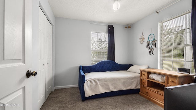 carpeted bedroom with a closet and a textured ceiling