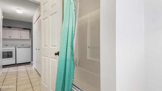 bathroom with shower / bath combination with curtain, washing machine and dryer, tile patterned floors, and a textured ceiling