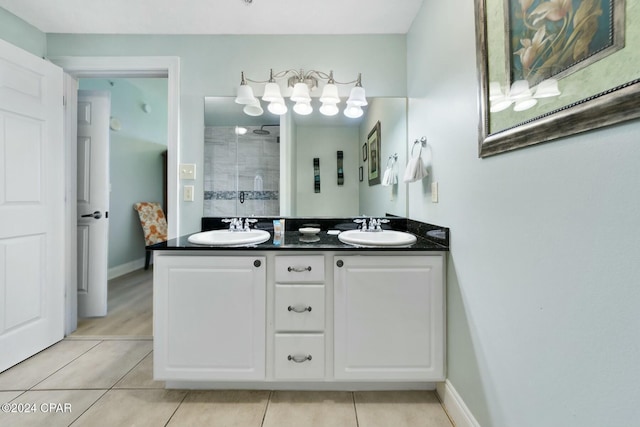 bathroom with tile patterned flooring, a sink, a tile shower, and double vanity