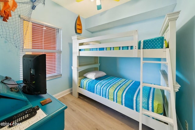 bedroom featuring a ceiling fan, baseboards, and wood finished floors