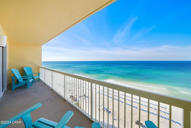 balcony featuring a water view and a beach view