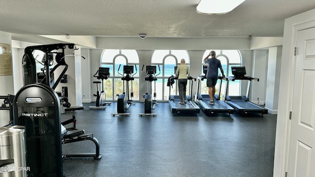 gym with baseboards and a textured ceiling