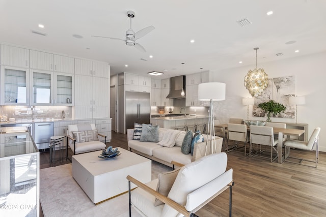 living room featuring ceiling fan, sink, and light hardwood / wood-style floors