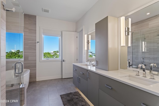 bathroom featuring tile patterned floors, a shower with door, and vanity