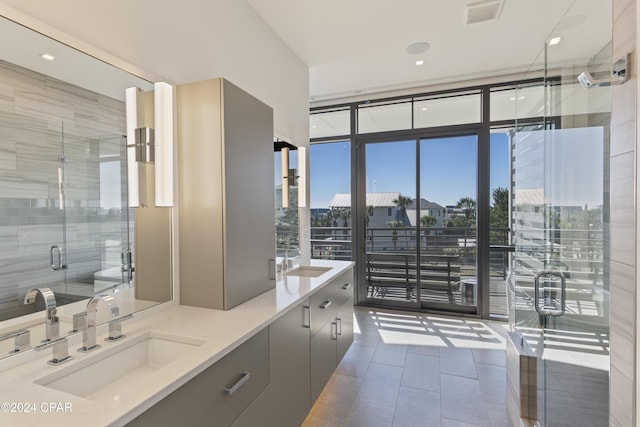 bathroom with tile patterned flooring, vanity, floor to ceiling windows, and a shower with shower door