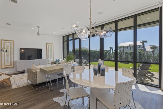 dining space featuring ceiling fan, a wall of windows, and dark wood-type flooring